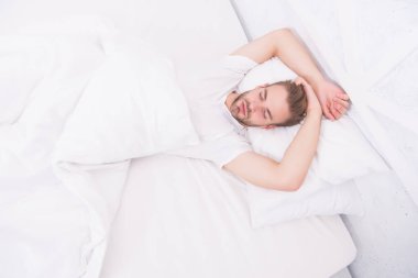 Sağlıklı uyku konsepti. Sağlıklı uyku alışkanlıklarını destekleyen ipuçları. Yatakta dinlenen yakışıklı adam. Düzenli olarak geceleri uyuyun. Yatmadan önce meditasyon gibi sakinleştirici aktiviteler üzerinde çalış