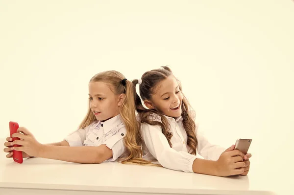 Traiga el poder del aprendizaje móvil al aula. Niños pequeños que tienen clase en teléfonos móviles aislados en blanco. Pequeños alumnos que usan dispositivos móviles en clase. Un divertido proyecto móvil — Foto de Stock