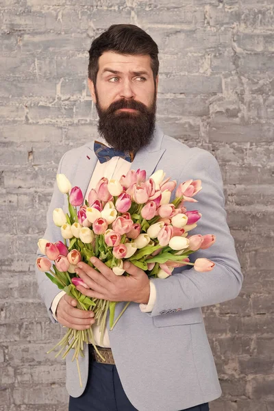 Blume für den 8. März. Bärtiger Mann mit Tulpenblumenstrauß. Liebesdatum. Feiertag. Frühlingsgeschenk Blumen. Bärtiger Hipster mit Blumen. Frauentag. Unmöglicher Geruch. Frühlingsallergie — Stockfoto