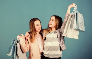 Çocuk modası. Paketli tezgahtar. Satış ve indirimler. Kardeşlik ve aile. Satın almada tasarruf. Alışveriş çantalı küçük kızlar. Mutlu çocuklar. Küçük kız kardeşler online alışveriş yapıyor.
