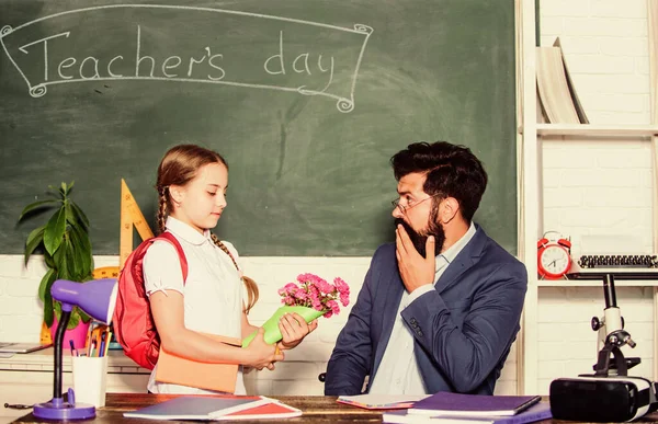 take this. flower present for best teacher. back to school. Happy teachers day. teachers day. Daugghter and father with flowers. knowledge day 1 september. small school girl kid with flower bouquet