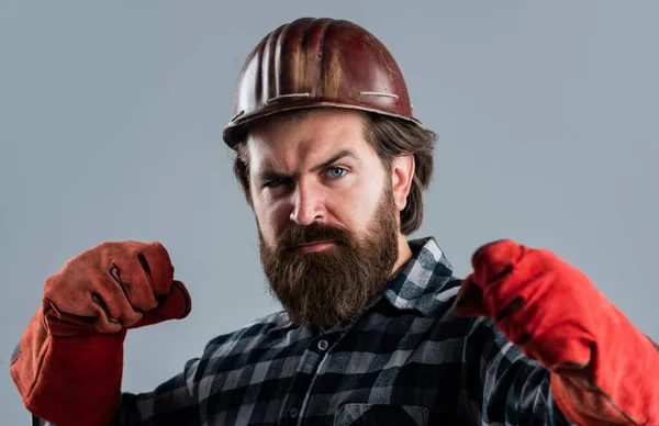 修理と建物。手袋をしろ。真剣な男労働者は堅い帽子をかぶる。ヘルメットの残酷な建築家。髭を生やした修理工。建設技術者だ。プロの建築家 — ストック写真