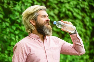 Limonata tazeleniyor. Soda. Su dengesi. Sakallı turist su içen plastik şişe doğası. Yaz sıcağı. Susamış adam şişelenmiş su içiyor. Sağlıklı bir yaşam tarzı. Sıcak bir gün
