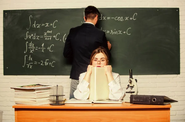 Faculdade STEM. Homem escrevendo em fórmulas de matemática quadro-negro. A dar aulas na universidade. No liceu. Educação universitária. Transferência de conhecimento. Professor e aluno perto do quadro. Ensino universitário universitário — Fotografia de Stock