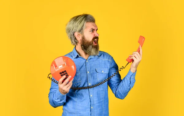 Conectar a la gente es asunto nuestro. Un joven hablando por teléfono. Hombre mayor hipster mostrando teléfono viejo. tipo brutal con teléfono. hombre barbudo maduro hablar por teléfono retro. vintage en la vida moderna — Foto de Stock