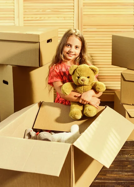 Moving routine. Only true friend. Girl child play with toy near boxes. Packaging things. Move out concept. Stressful situation. Divorce and separation. Family problem. Prepare for moving. Moving out — Stock Photo, Image
