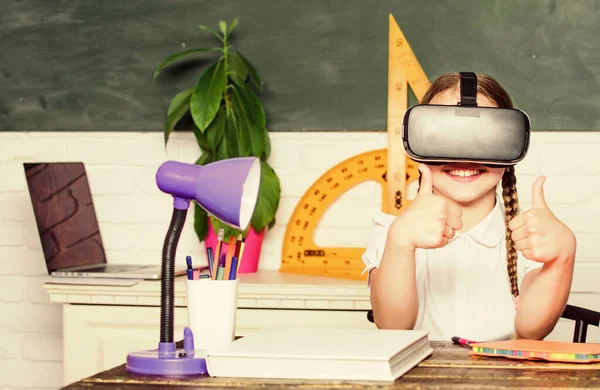 Studying in virtual reality. Modern technology. Interesting lesson. Homeschooling online. Girl kid study in virtual school. Virtual education. Child cute pupil wear hmd vr glasses. Virtual teaching