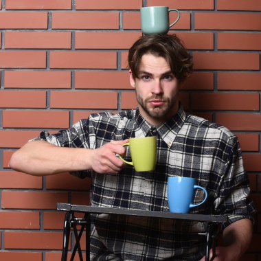 Duvarda bardakları tutan yakışıklı adam.