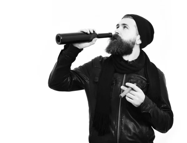 Bärtiger brutaler kaukasischer Hipster trinkt aus Flasche und raucht Zigarre — Stockfoto