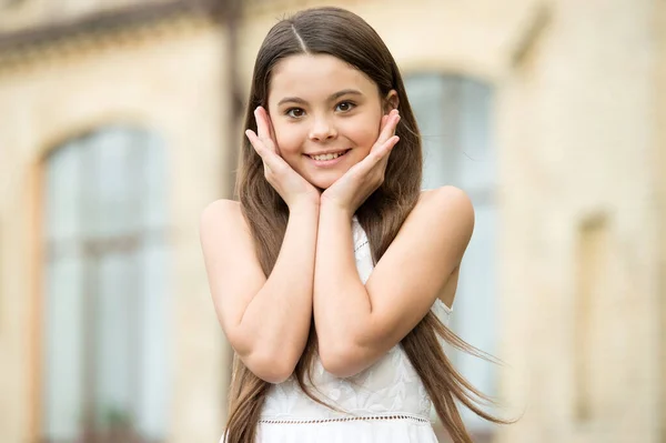 幸せな子供の長い髪の笑顔都市の背景屋外で、魅力的な子供の概念 — ストック写真