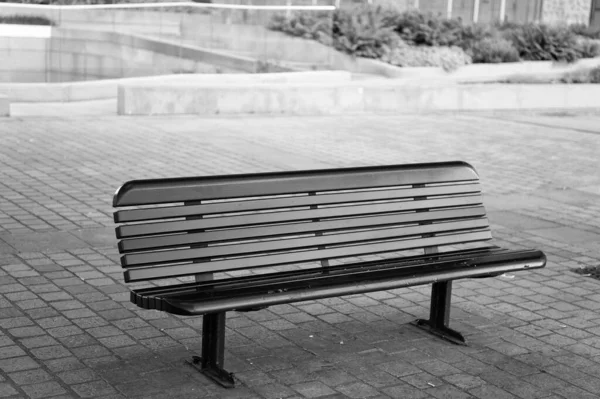 Mobiliario urbano. Banco o asiento al aire libre. Banco de ciudad con respaldo. Banco de la calle en la losa de pavimentación. Descansa y relájate. Disfrute de su entorno —  Fotos de Stock