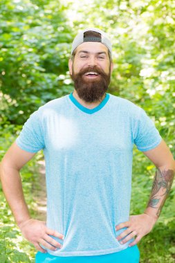 Doğaya giden yollar. Kamp yapmaya hazırım. Erkek sakallı turist şapkası takıyor. Spor ve spor kıyafetleri. Mutlu ve yakışıklı vahşi adam. Bıyıklı, vahşi, beyaz bir hippi. Gülümseyen sakallı adam