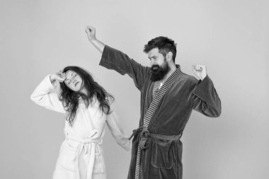 Yarı uyanık. Aşık çift sabahları uykulu görünüyor. Uykulu kadın ve hipster esneme ve esneme mavi arka plan. Sabahın köründe. Yorgun ve uykulu olmak. Ev kıyafetleri. Uyanış. Uykum geldi.