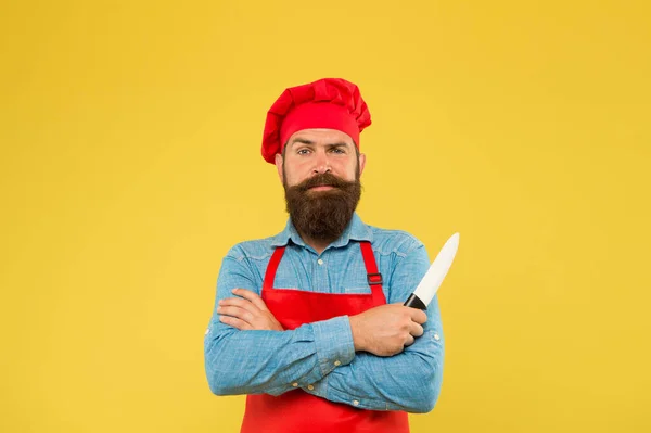 Voel je lekker eten. Beste menu aanbod. zelfverzekerde bebaarde chef-kok rood uniform. Mannelijke chef met mes gesneden. volwassen hipster met serieus gezicht. De bebaarde chef kruiste de handen. brutale slager in schort — Stockfoto