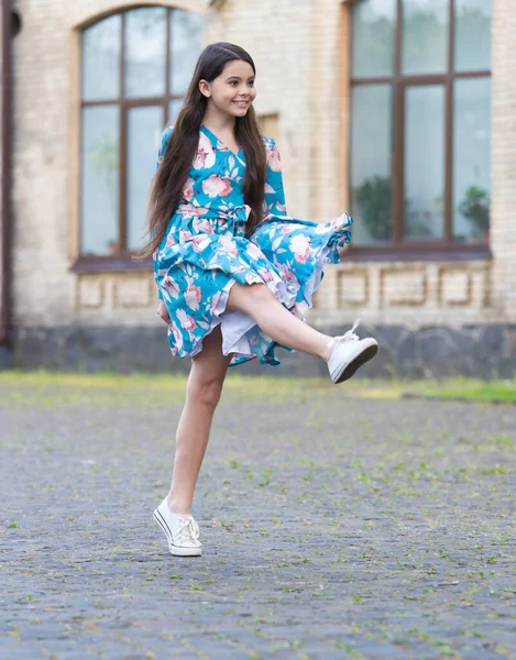 Ragazza vestito estivo svolazza in movimento sfondo urbano, concetto di bambino attivo — Foto Stock