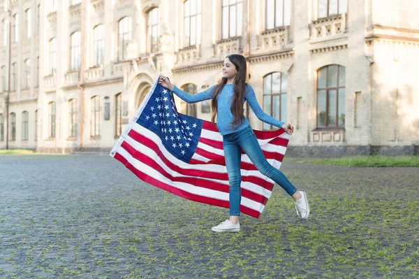 Bambina con bandiera americana all'aperto sfondo architettura, concetto di coscienza nazionale — Foto Stock