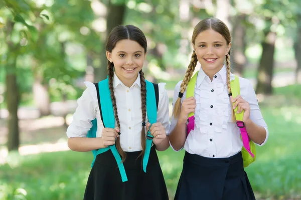 Playful mood. Fashion little girls with backpack in park. children with backpack smiling. students outside in summer park smiling happy. girls with school bags. child with backpack. happy time — Stock Photo, Image