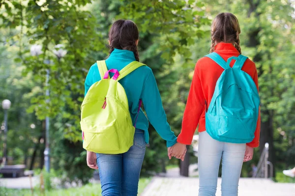 Meisjes backpackers vrienden fleece kleding rugzakken bos achtergrond, hand in hand concept — Stockfoto