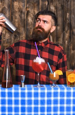 Uzun sakallı, bıyıklı ve şık saçlı bir barmen.