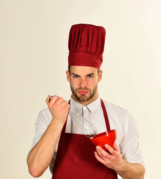 Чоловік у кулінарній шапці і фартух тримає інструменти . — стокове фото