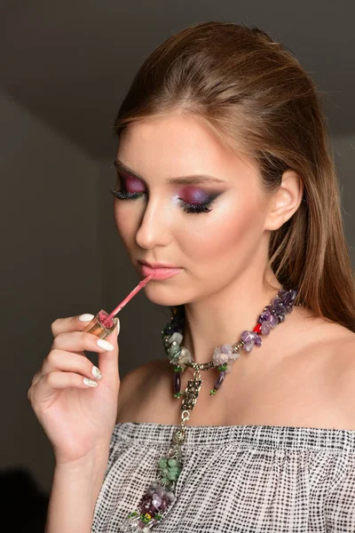Model schilderij lippen met lipgloss met verleidelijke gelaatsuitdrukking — Stockfoto