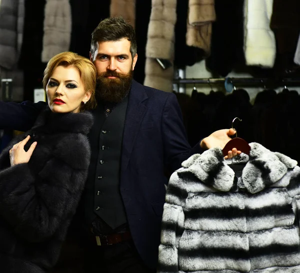 Muž a dívka s vážnými tvářemi drží chlupaté kabáty — Stock fotografie