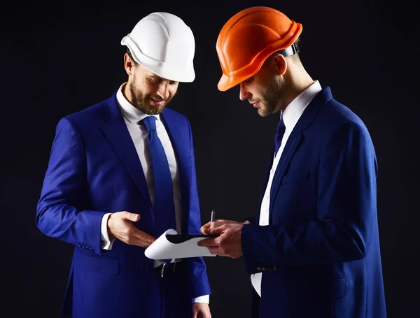 Ingenieros con caras sonrientes miran el proyecto . —  Fotos de Stock