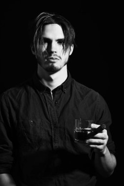 Stüdyoda viski içen ciddi sakallı adam.