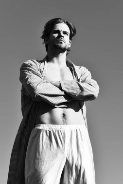 Mavi çizgili pijamalı, mavi güneşli arka planda beyaz maço.