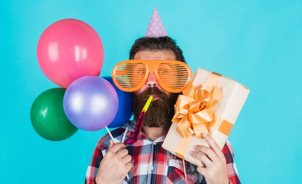 Efter att ha handlat. Firar en glad fest. Partielement och semesterföremål. Flerfärgat roligt. Bästa festen för pensionering. Glada man med skägg hålla närvarande. hipster leende med ballong — Stockfoto