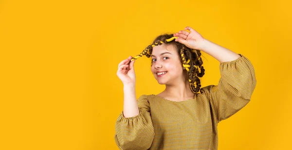 어린 시절의 행복. 미용사 미용실에서 미장원을 하는 행복 한 소녀. 아이들에게 머리 스타일을 만드는 것은 쉬운 일이죠. 미용 도구와 헤어 액세서리. 애가 미장원하고 포즈를 취하고 — 스톡 사진