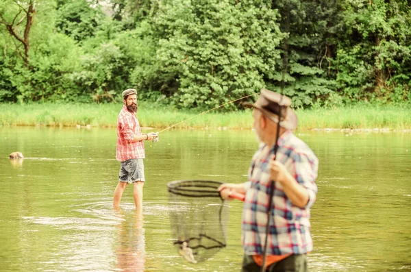 Pescatore con canna da pesca. Attività e hobby. Pesca d'acqua dolce lago stagno fiume. Uomini barbuti che catturano pesci. Uomo maturo con amico pesca. Vacanze estive. La vita è sempre migliore quando sono a pesca — Foto Stock