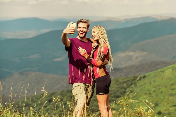 Tomemos una foto. Capturando belleza. Hombre y mujer posando foto móvil. Una pareja tomando fotos. Concepto vacaciones de verano. Jóvenes aventureros. Viajan juntos con cariño. Pareja enamorada senderismo montañas — Foto de Stock