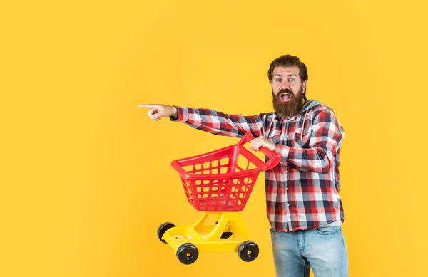 Un vrai accro du shopping. acheteur au supermarché. chariot à jouets vide. Une femme de ménage très occupée. mari parfait. J'ai besoin d'une liste. homme barbu aller faire du shopping avec jouet panier vide. client poussant chariot — Photo