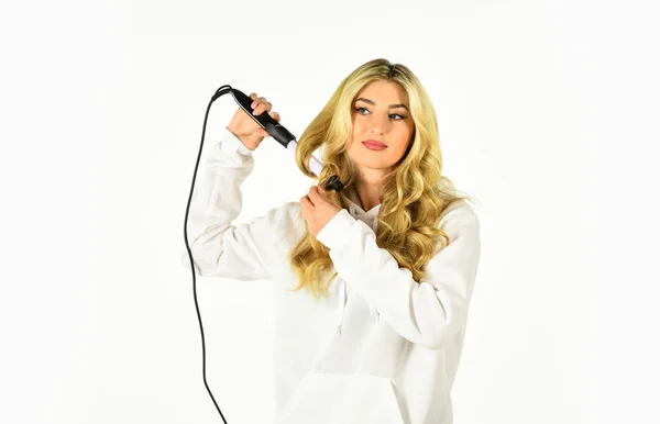 Peinado y peluquería. chica rizando pelo largo con rizador. A la chica le importa su peinado. mujer rizando el pelo con alisador. mujer peinando su cabello con una rizadora —  Fotos de Stock