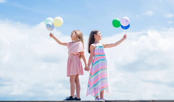 Sommarsemester. Små flickor omfamnar. Kärlek och stöd. systerskap och vänskap. Dags för familjeband. bästa vän med ballong. Två systrar har festballong. lycklig barndom — Stockfoto