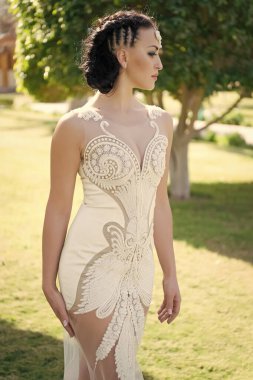 Şehvetli gelin. Gelin lüksü, beyaz gelinlik güneşli bir gün, tropik doğa geçmişi. Tropik düğün. Kadınlar tropikal düğün törenlerinde harika elbiseler giyerler. Egzotik gelin kıyafeti