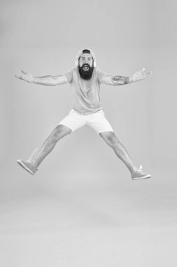Partiye katıl. Adam müzik dinliyor kablosuz kulaklıklar hareket halinde. Sakallı adam müzikten hoşlanıyor. Hippi dansı, zıplayan kulaklıklar. İlham verici bir şarkı. Müzik kütüphanesi. Canlandırıcı müzik. DJ neşeli adam.