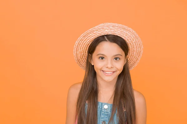 Un atuendo elegante. Moda de verano. Buenas vibraciones. Estilo playa. Belleza en sombrero. Retrato de chica alegre feliz en el fondo naranja sombrero de verano. Vacaciones de verano. Chica vestida a la moda. Disfrutando de las vacaciones —  Fotos de Stock