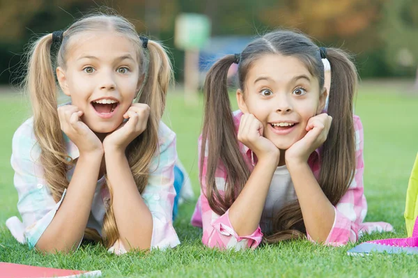 Lindo sonriente niños hermanas relajarse verde hierba, real sorpresa concepto — Foto de Stock