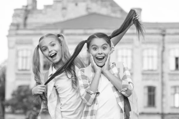 Tieni i capelli lunghi. I bambini felici tengono i capelli lunghi. Ragazze della scuola in treccine. Acconciatura lunga alla moda. Stimolante per la crescita dei capelli lunghi. Estensioni per capelli naturali. Salone che tiene a te. Cura dei capelli — Foto Stock