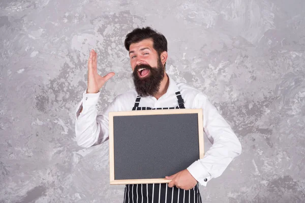 Man good looking hospitable restaurant waiter with blackboard copy space, meal of the day concept