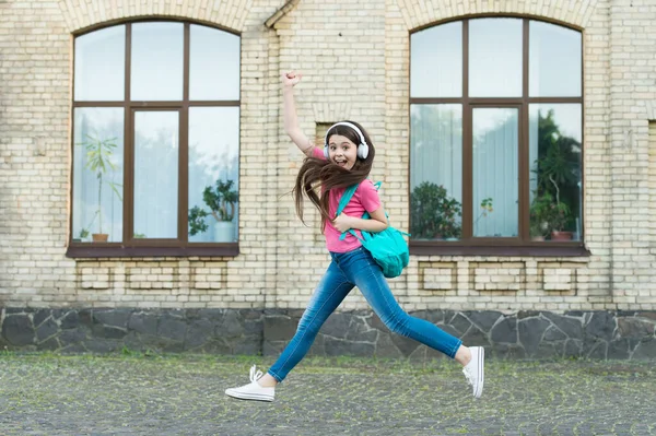 Menina criança energética pulando dançando ouvir fones de ouvido música, conceito de dança feliz — Fotografia de Stock