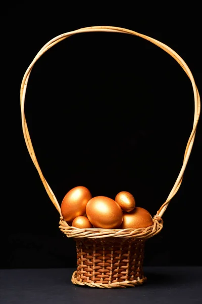 Traditional eggs painted in golden color inside pottle or basket — Stock Photo, Image