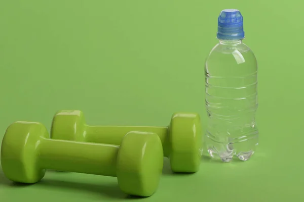 Dumbbells in bright green color and water bottle