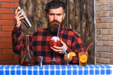 Uzun sakallı, bıyıklı ve şık saçlı bir barmen.