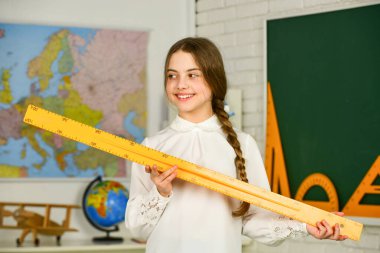 En sevdiği okul konusu. Eğitim ve okul konsepti. Öğrenci geometrisi öğreniyor. BTMM konsepti. Geometrik şekiller çiz. Çocuk okul üniforması. Öğrenmeyi zilin ötesine genişlet. Cetvelli şirin kız.