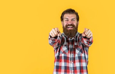 Genç ve vahşi. Kendine güvenen ve yakışıklı vahşi bir adam. kopyalama alanı. Ekose gömlekli yakışıklı sakallı adamın portresi. Sıradan kıyafetler giyen bir adam. vahşi, mutlu, sakallı adam içeride duruyor.