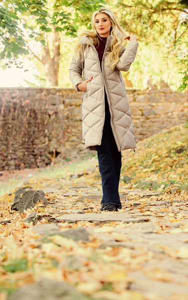 Oversized jastrend. Kogelvrij vest casual en comfortabele stijl. Een vrouw draagt een warm grijs jasje. Jas die iedereen zou moeten hebben. Puffer mode trendconcept. Meisje modieuze blonde wandeling in de herfst park — Stockfoto