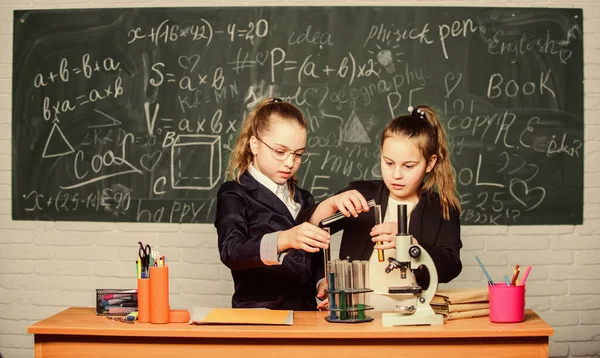 Pesquisa de química. Crianças usando microscópio. Raparigas no laboratório da escola. Microscópio. Lição de biologia. A verificar os resultados. Um pequeno cientista trabalha com microscópio. experimentos científicos em laboratório — Fotografia de Stock